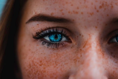 Woman with freckles and stunning aquamarine eyes. 